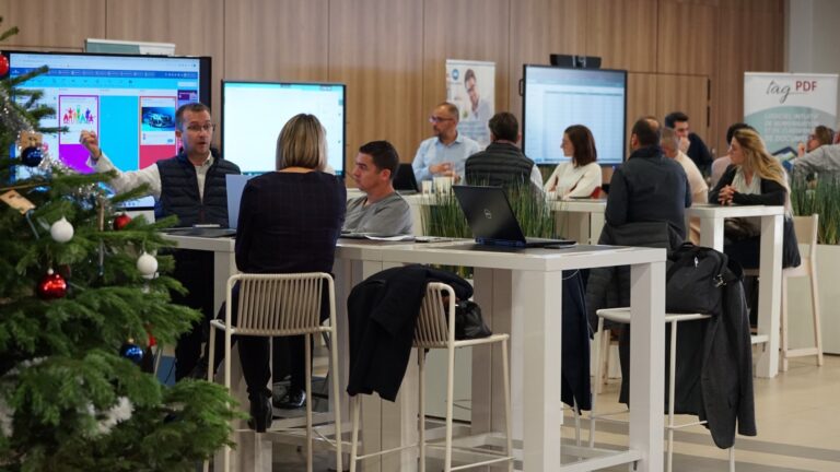 Réunion d'équipe en bureau moderne avec ordinateurs.