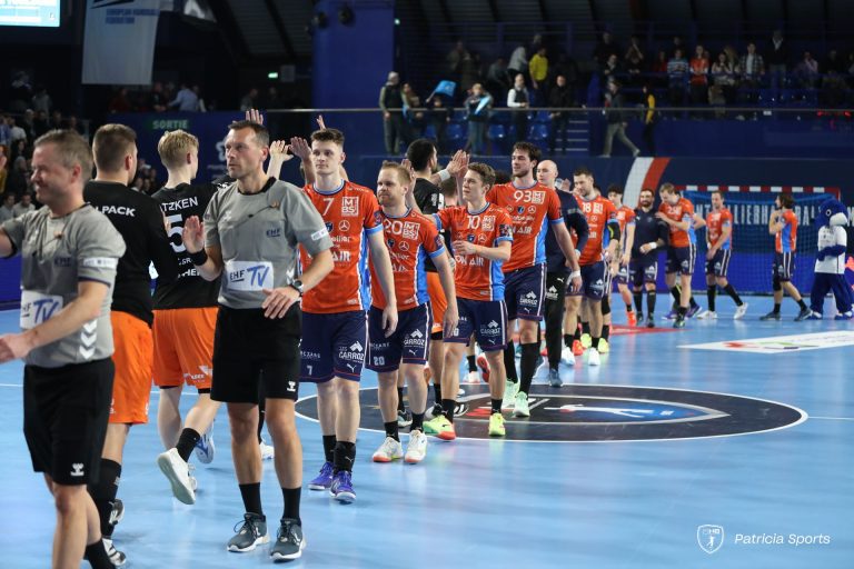 Équipe de handball saluant sur le terrain.