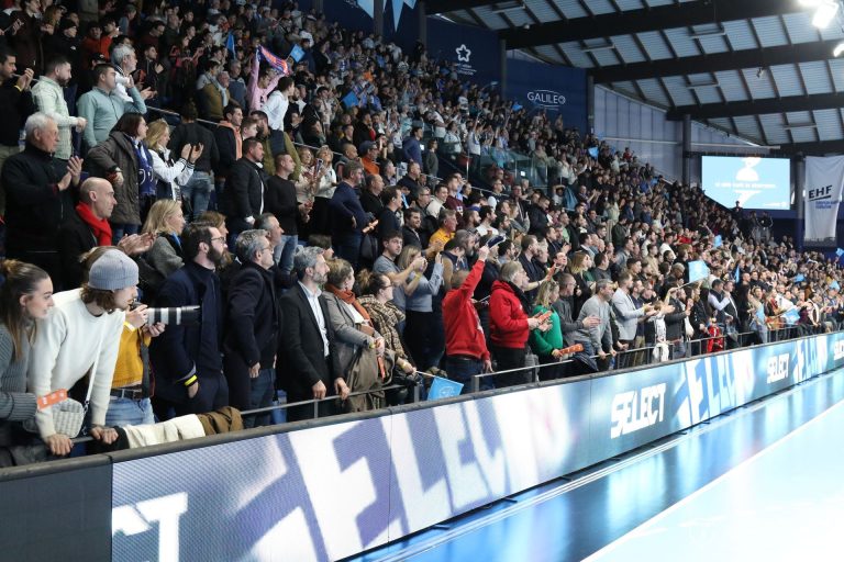 Supporters enthousiastes dans une salle de sport pleine.