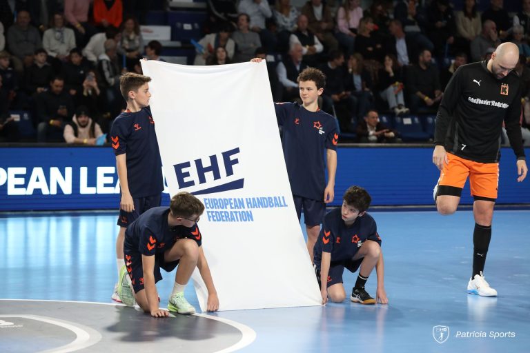 Jeunes portant drapeau EHF sur le terrain.