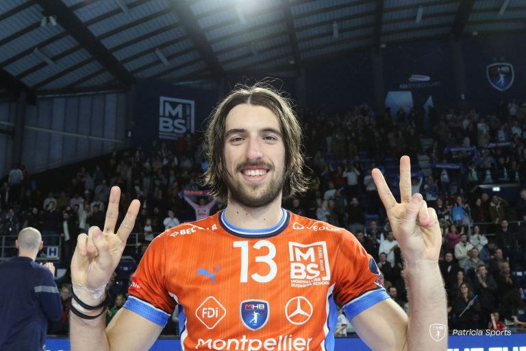 Joueur de handball souriant en maillot orange.