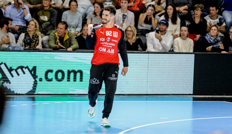 Joueur de handball souriant sur le terrain.