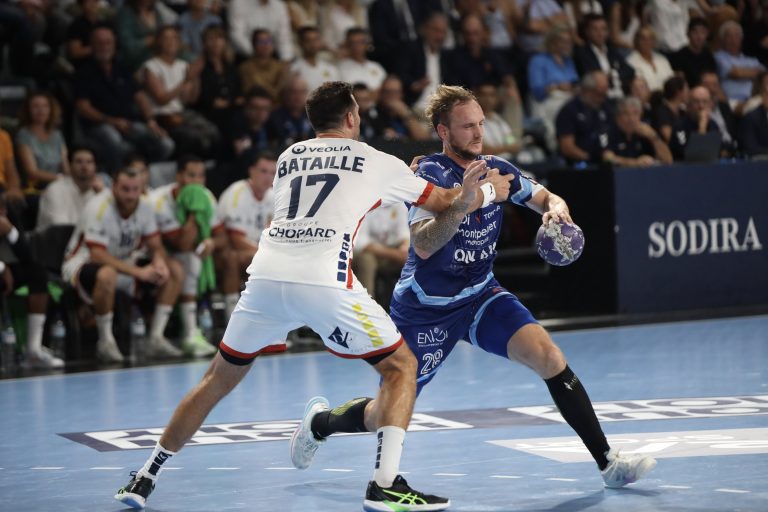Match de handball intense entre deux joueurs.