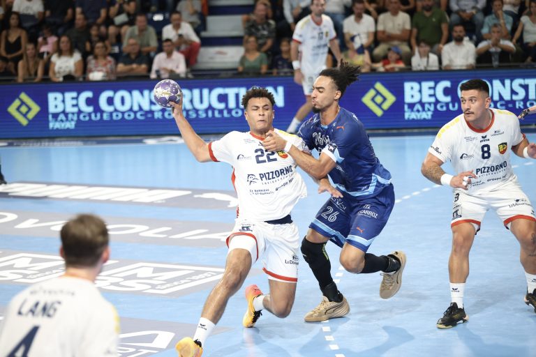 Match de handball intense en salle, deux équipes s'affrontent.