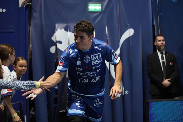 Joueur de handball saluant des fans avant le match.