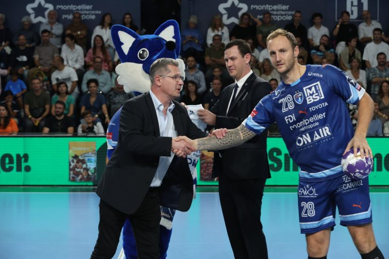 Joueur de handball récompensé par un officiel.