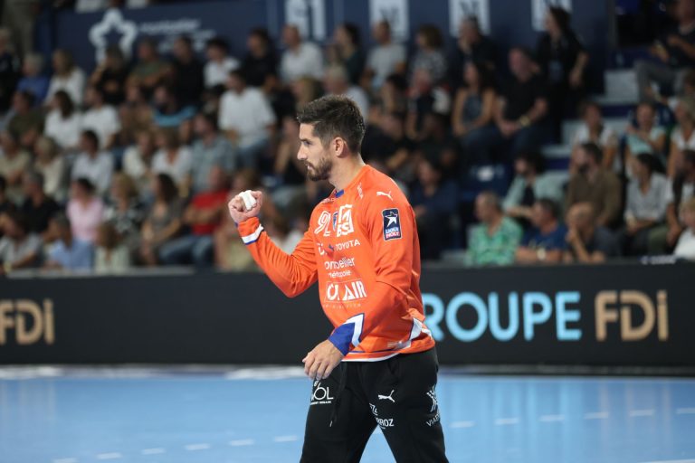 Joueur de handball en action, maillot orange.