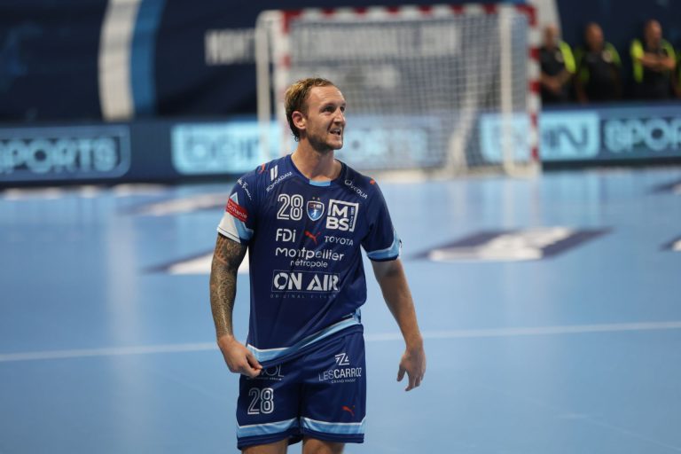 Joueur de handball sur le terrain bleu.