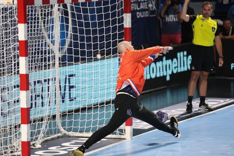 Gardien de handball parant un tir en match.