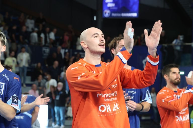 Joueur de handball applaudissant lors d'un match.