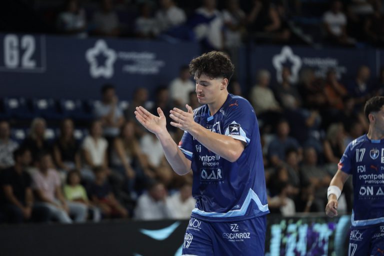 Joueur de handball applaudissant sur le terrain.