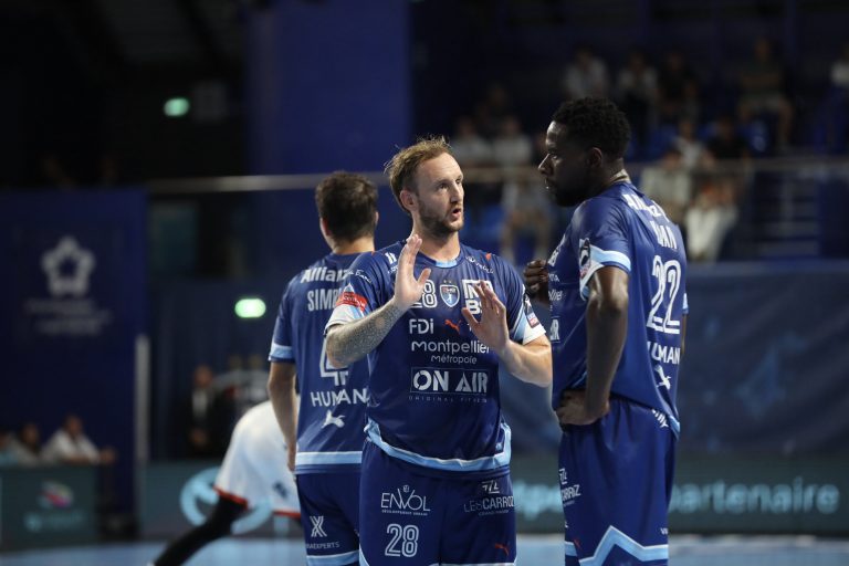 Joueurs de handball en discussion sur le terrain.