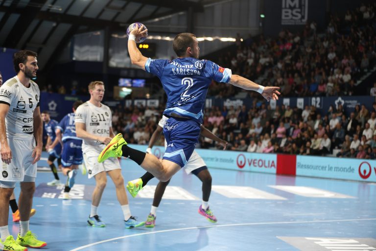 Joueur de handball en plein saut durant le match.