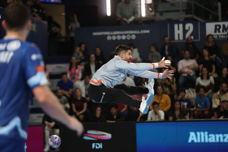 Gardien de but plongeant lors d'un match de handball.
