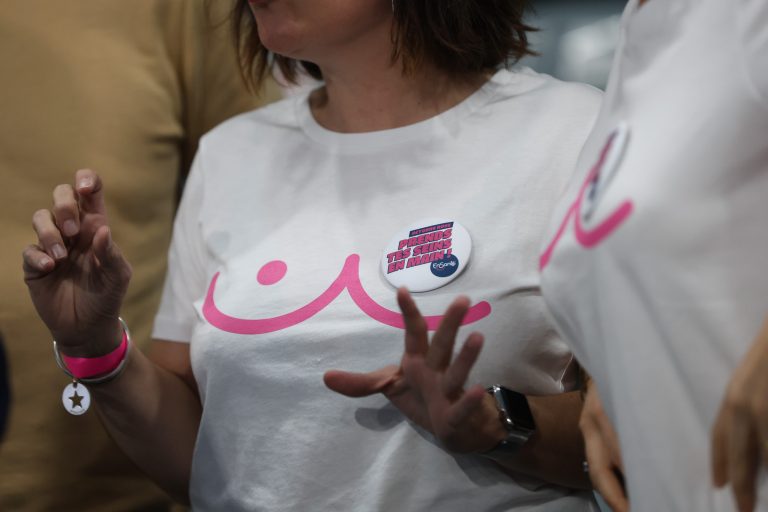 T-shirt blanc avec logo rose et badge inspirant.
