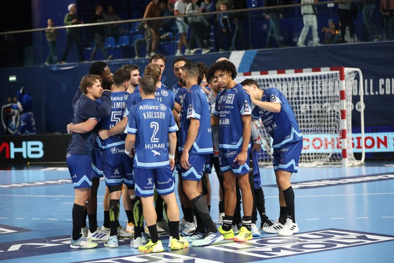 Équipe de handball en cercle sur le terrain.
