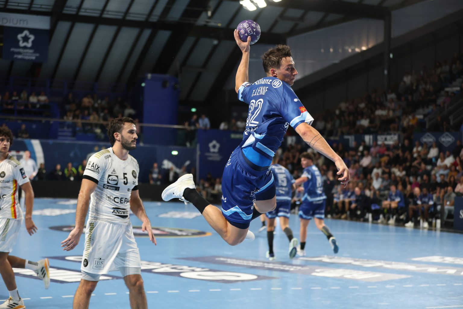 Joueur de handball en plein saut pour marquer.