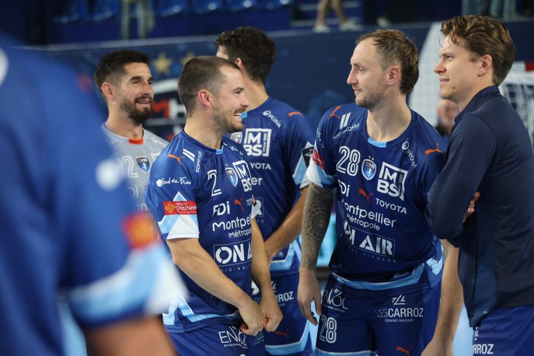 Joueurs de handball discutant sur le terrain.