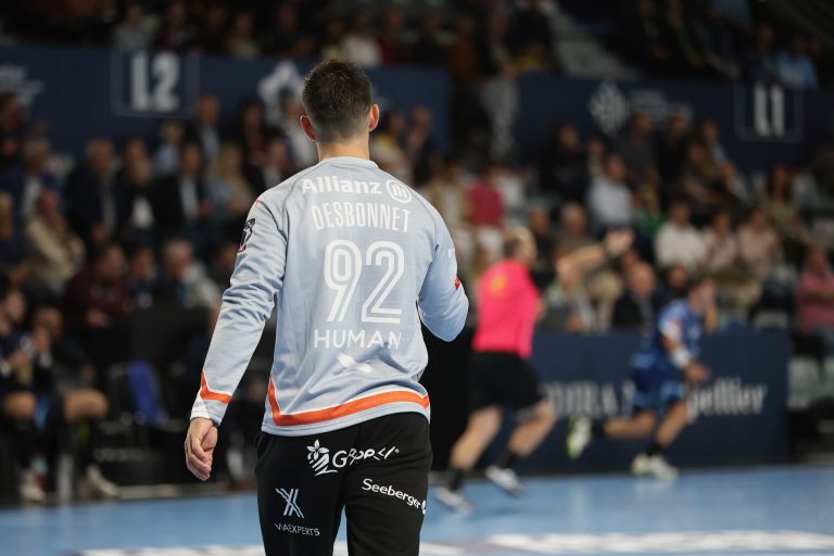 Joueur de handball sur terrain lors d'un match.