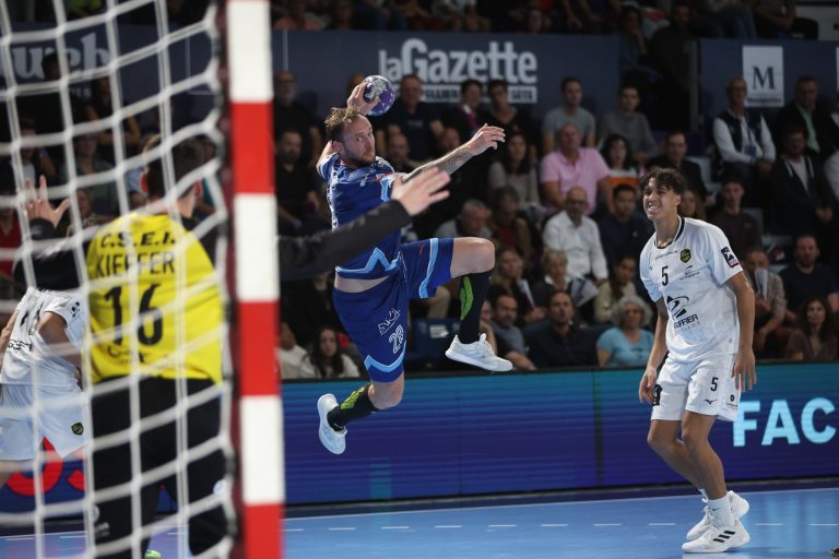 Joueur de handball tirant au but en match.