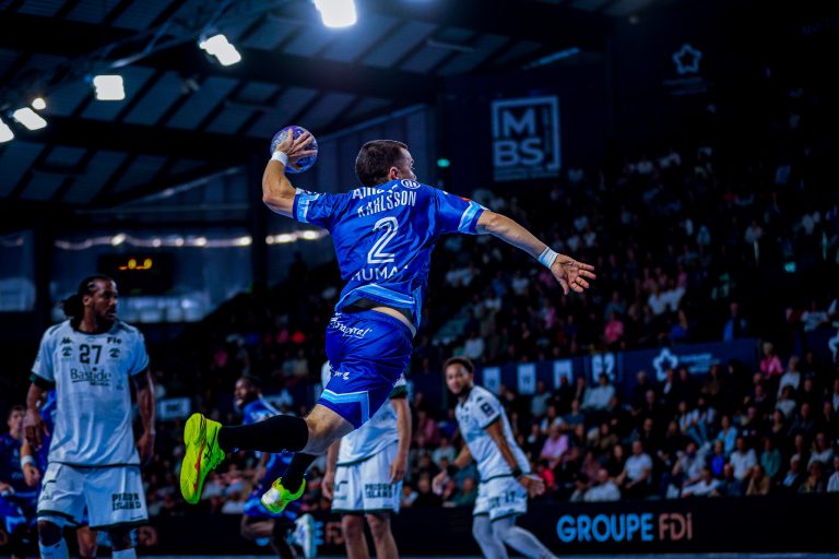 Joueur de handball lançant une balle en l'air.