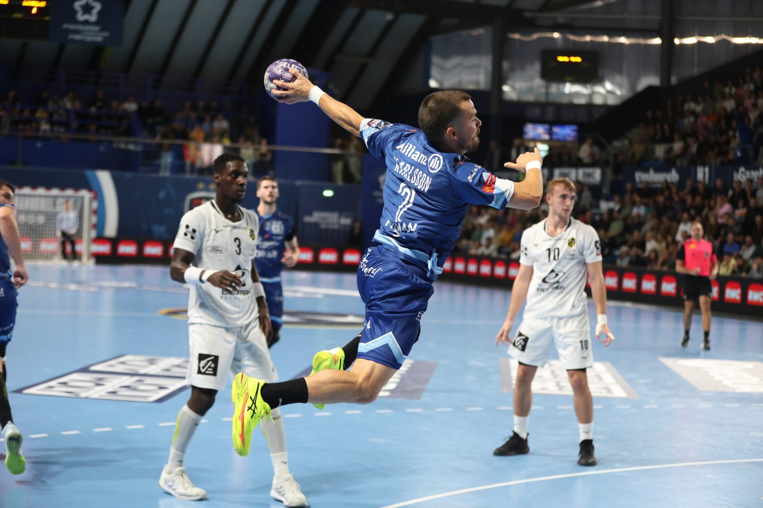 Joueur de handball en plein saut, tir au but.