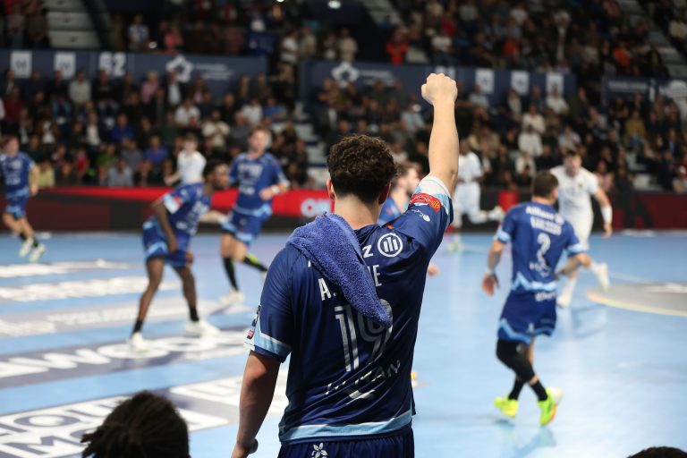 Joueur de handball encourageant l'équipe sur le terrain.