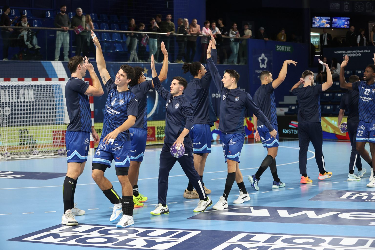 Équipe de handball célébrant sur le terrain.
