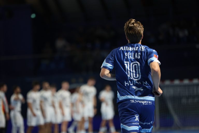 Joueur de handball en action, dos au spectateur.