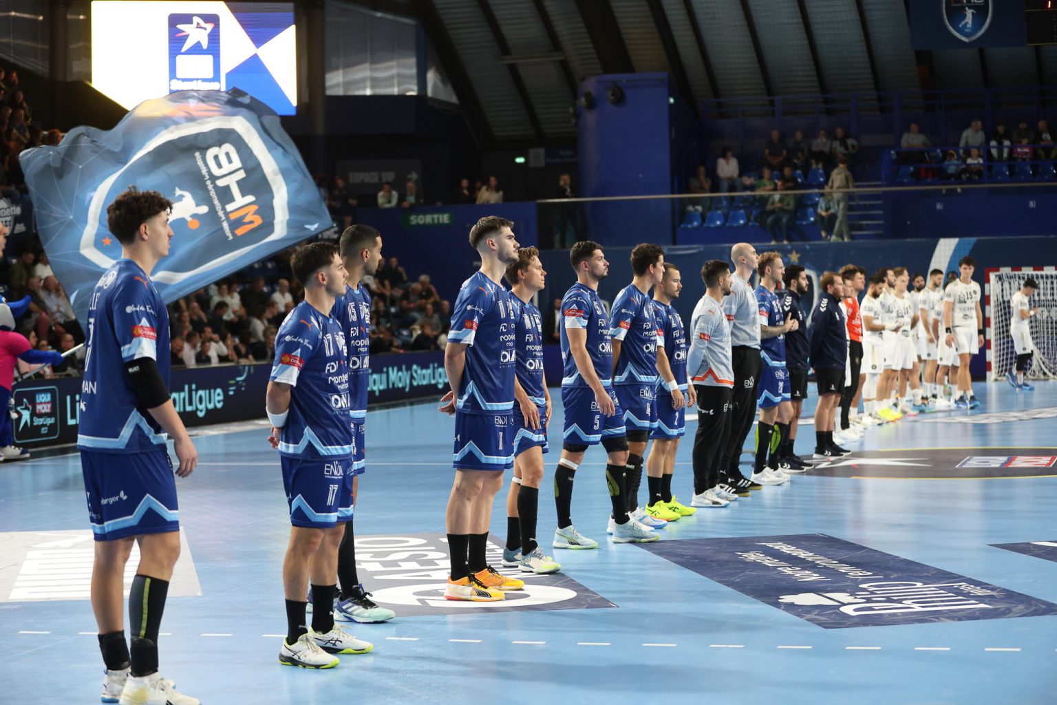 Équipes de handball alignées avant le match.