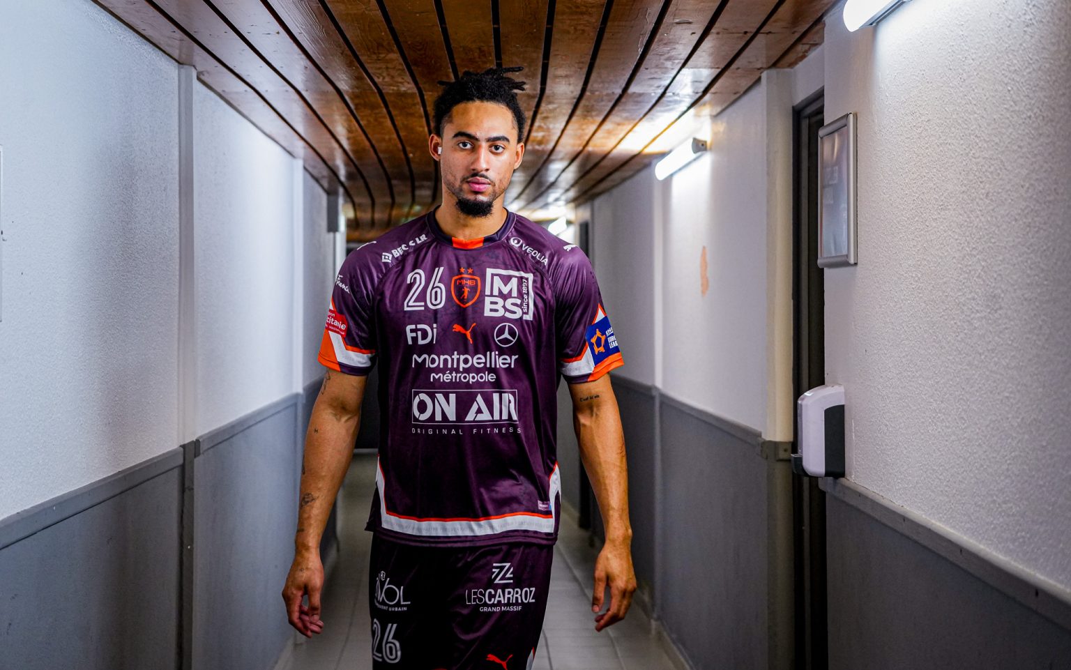 Joueur de football dans un couloir du stade.