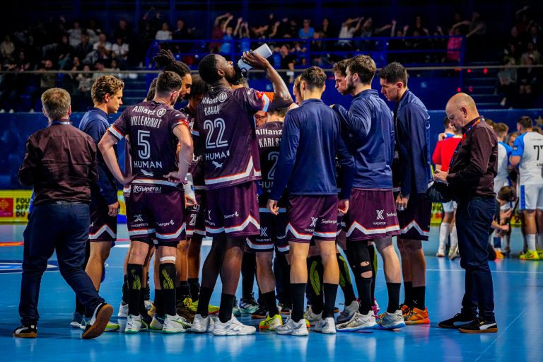Équipe de handball en discussion sur le terrain.