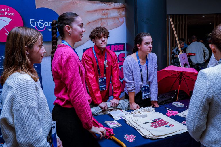 Stand associatif avec jeunes participants en discussion.