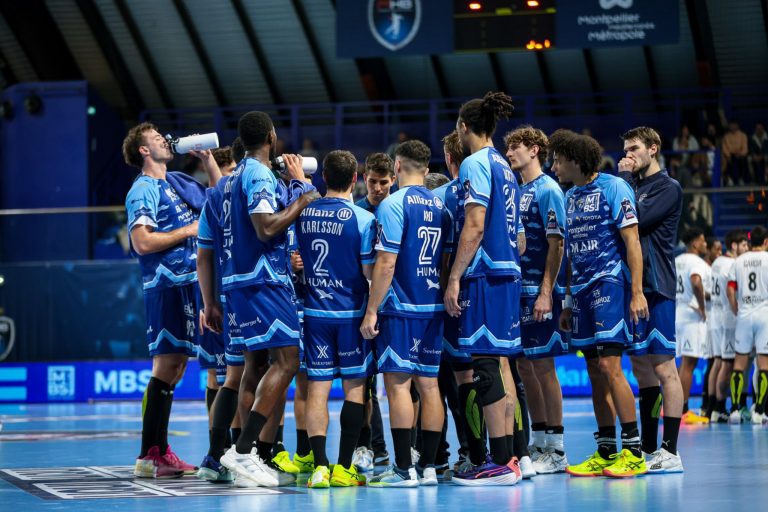 Équipe de handball en réunion sur le terrain.