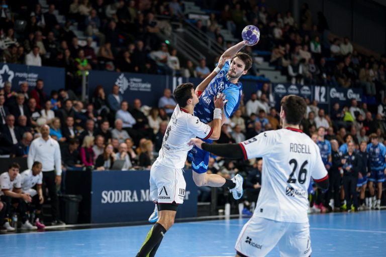 Match de handball en salle, joueur en action.