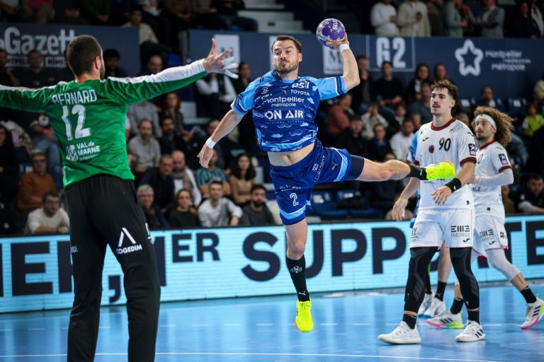 Joueur de handball en plein saut pendant un match.