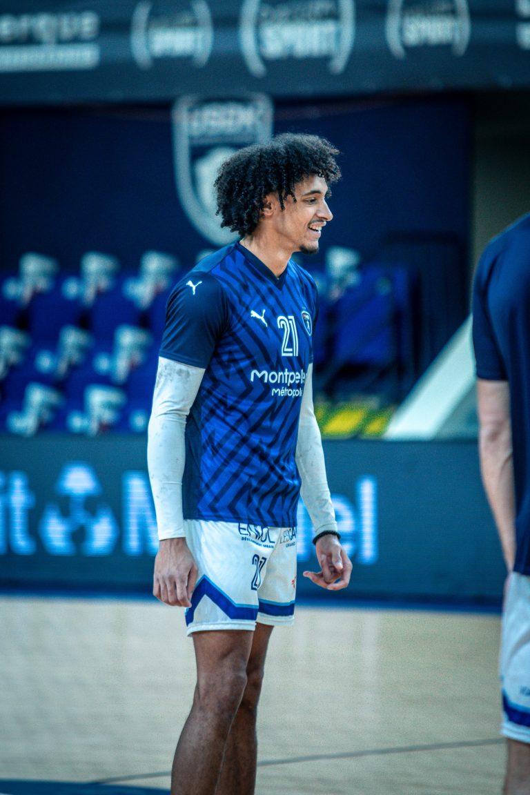 Joueur de handball en tenue bleue sur le terrain.