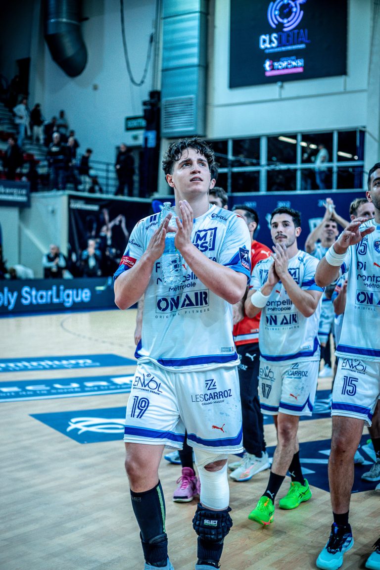 Joueurs de handball applaudissant sur le terrain.