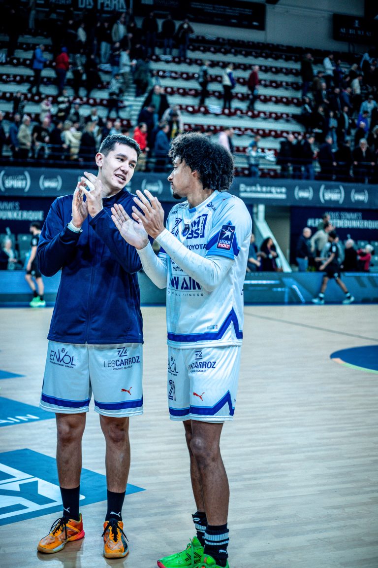 Deux joueurs de handball discutent sur le terrain.