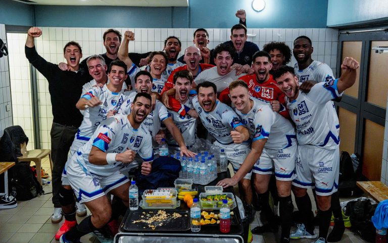 Équipe de handball célébrant dans le vestiaire.