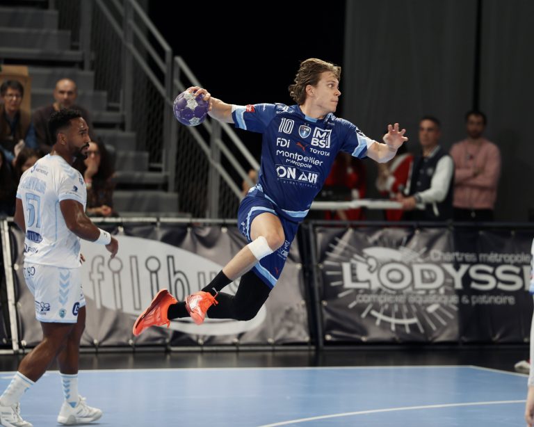 Joueur de handball en plein saut lors du match.