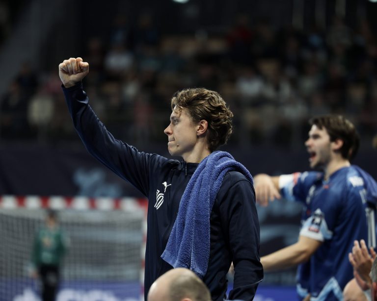 Joueur de handball lève le poing, match intense.