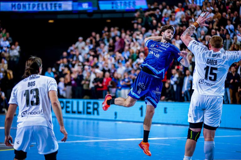 Match de handball, joueur en action aérienne.