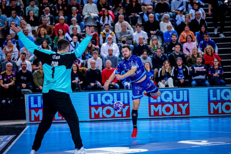 Joueur de handball en plein tir au but.