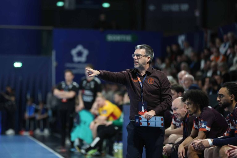 Entraîneur de handball donne des instructions sur terrain.