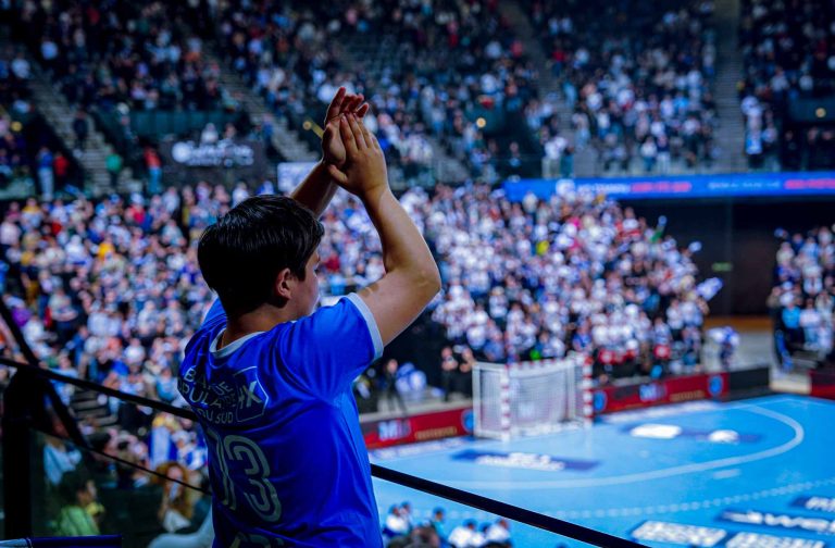 Supporter applaudissant lors d'un match de handball.