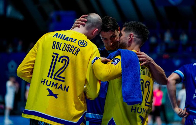 Joueurs de handball en discussion sur le terrain.