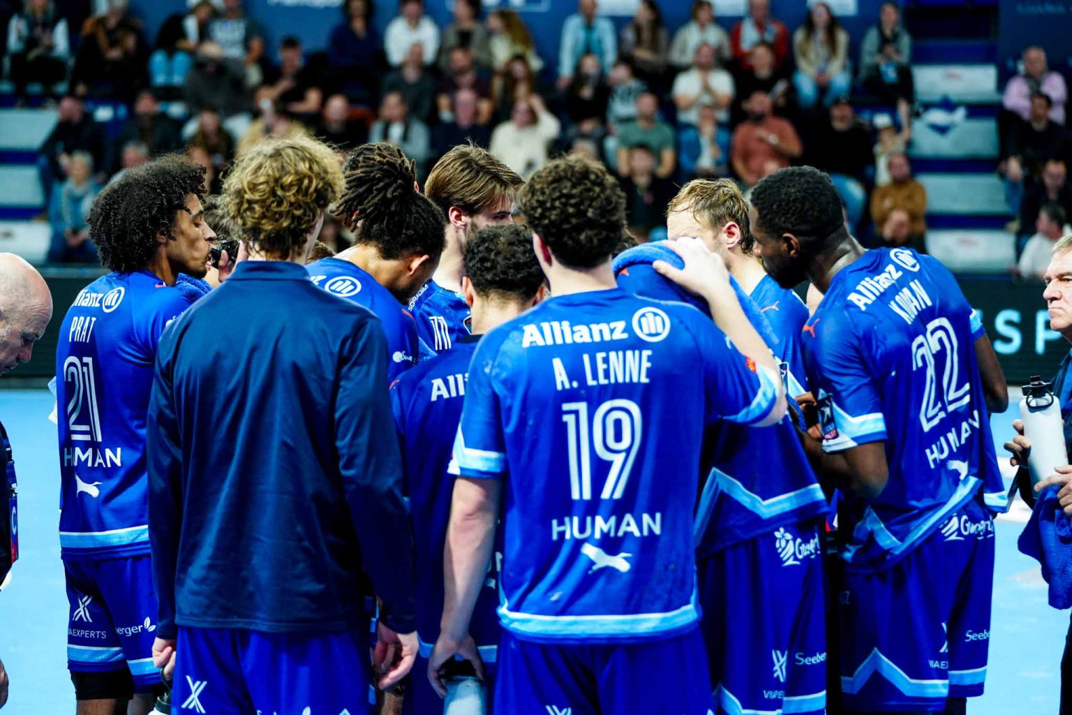 Équipe de handball en discussion sur le terrain.