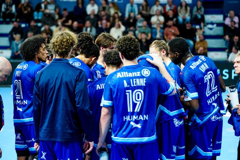 Équipe de handball en discussion sur le terrain.
