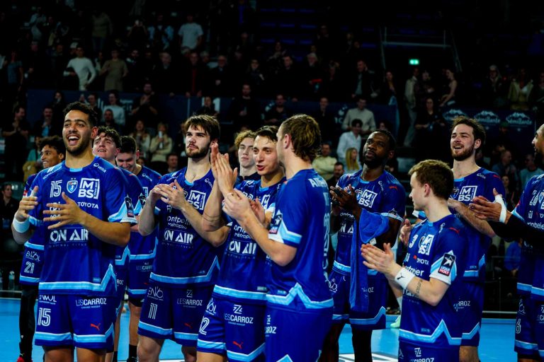 Équipe de handball en tenue bleue célébrant.